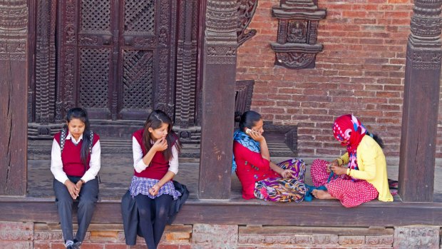 Local women and school girls hanging out on the steps of a temple in Bhaktapur's old town.