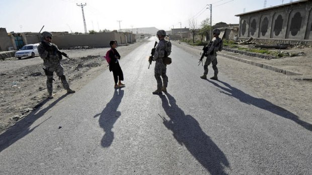 US soldiers talk with an Afghani school boy.