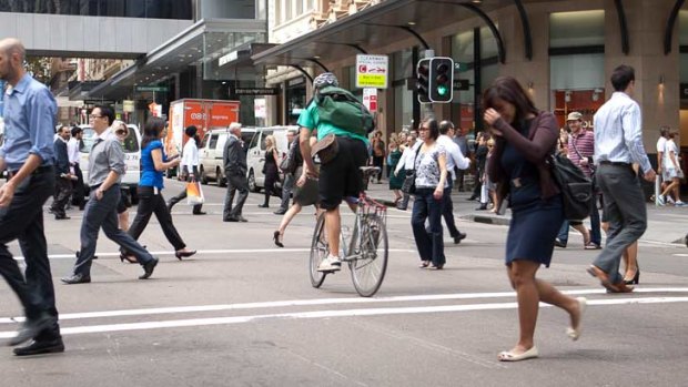 Anything goes ... a cyclist, pedestrians and a green light on a busy city street.