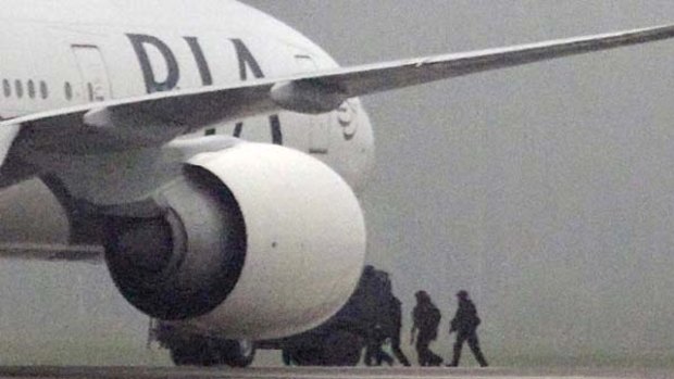 Swedish police approach a Pakistan Airlines jet which landed at Arlanda Airport near Stockholm following a bomb threat.