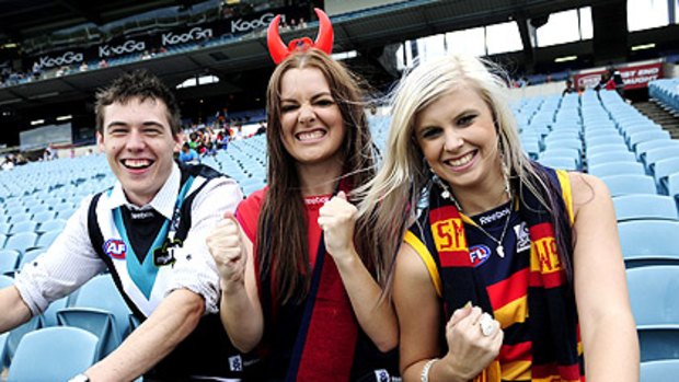 Three cheers for footy: (from left) Port Adelaide fan Simon Vigar, Demon supporter Lauren Porter and Crows fan Kate Lindenberger at AAMI Stadium last night.