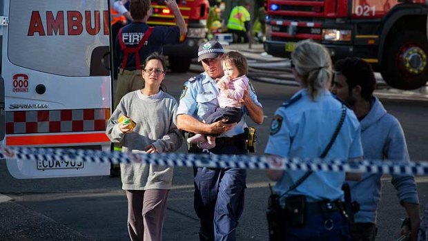 Police lead residents away from the units yesterday.