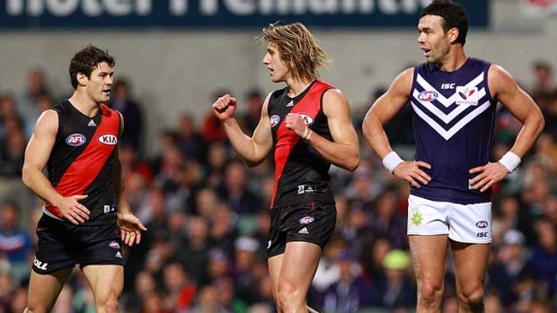 Dyson Heppell of the Bombers (centre) celebrates a goal.