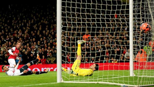 One-nil: Santi Cazorla of Arsenal scores the opening goal past goalkeeper Hugo Lloris of Spurs.