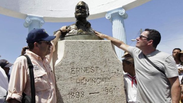 John Hemingway (left) and Patrick Hemingway (right), grandsons of the US author Ernest Hemingway, pay tribute to their grandfather at his statue in Cojimar village, Havana.