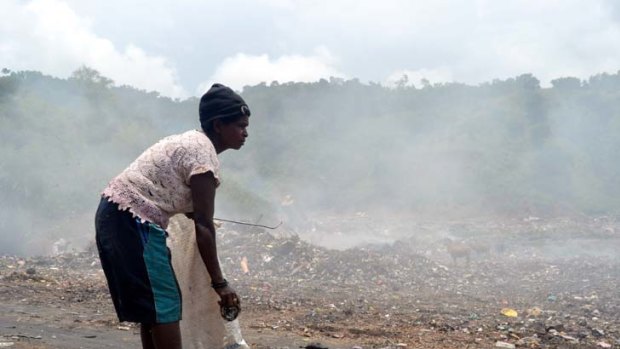 Contrast in hope ... Madalena Soares forages at Dili's dump and the Timor Plaza shopping mall.