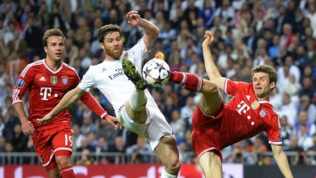 Real Madrid's midfielder Xabi Alonso (C) vies with Bayern Munich's midfielder Mario Goetze (L).