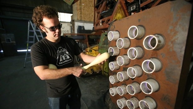 Megabots co-founder Gui Cavalcanti holds ammo fired from a side-mounted gun on the Mk II robot.