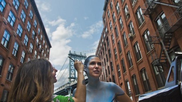 Trina Merry, left, paints model Jessica Mellow in colours of the Manhattan Bridge in the Brooklyn borough of New York.