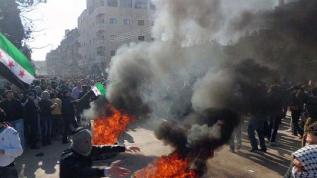 A nation divided ... regime protesters burn tyres in  the Damascus suburb of Daraya.