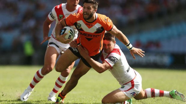 Solid defence: Dragons star Gareth Widdop grounds James Tedesco of the Wests Tigers.