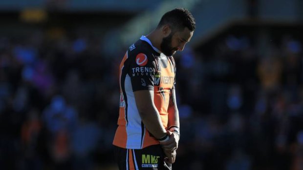 Tigers back Benji Marshall stands with his head bowed during a minute's silence for Robbie Farah's mum, who died on the eve of the game.