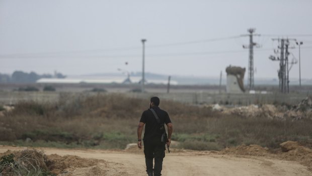 A member of the Qassam Brigades, Hamas's armed wing, walks along the road known as Jakar Street, parallel to the fence separating the Gaza Strip from Israel.