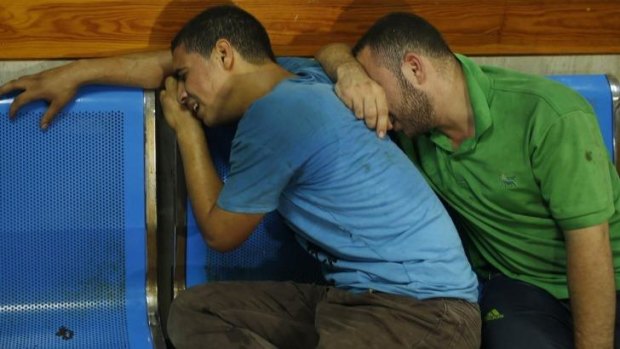 Palestinian men mourn after their relatives were killed in an Israeli air strike in Gaza.