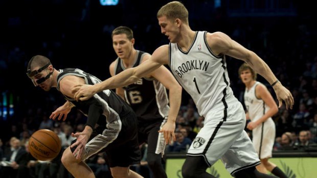 San Antonio Spurs guard Nando De Colo is covered by Brooklyn Nets rookie Mason Plumlee at the Barclay Center in New York.