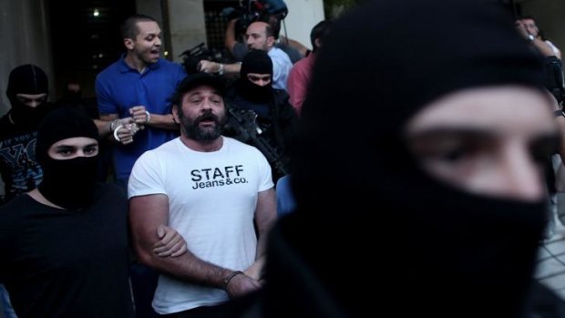 Yannis Lagos (front) and Ilias Kasidiaris (back) are escorted by masked police officers in September last year.