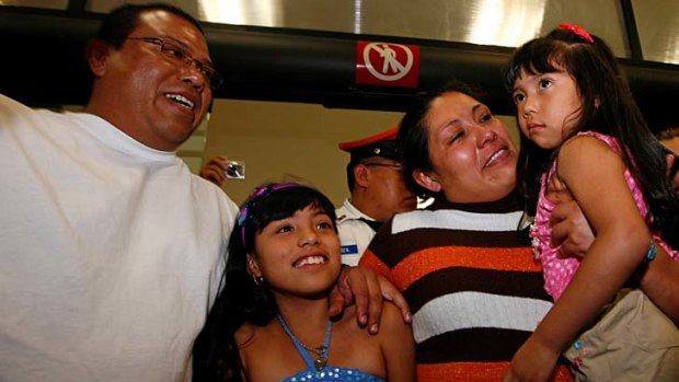 Together again ... Margarita Almaraz and Alfonso Mejia embrace their two daughters, Ashanti, centre, and Ashley.