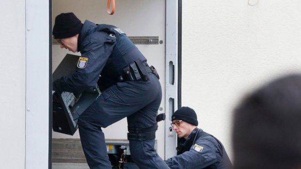 German police officers carry computers out of a mosque during a terror raid in Frankfurt.