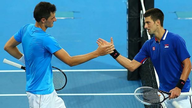Bernard Tomic of Australia is congratulated by Novak Djokovic of Serbia after winning his singles match during day five of the Hopman Cup.