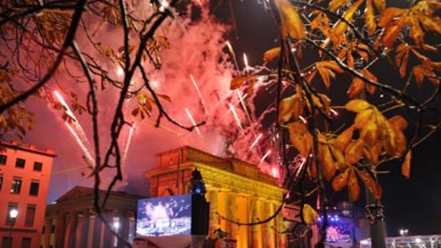 Another brick in the wall... crowds watch the fireworks at the Brandenburg Gate during 20th-anniversary celebrations.