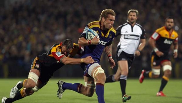 Jarrad Hoeata of the Highlanders is tackled by Hayden Triggs of the Chiefs.