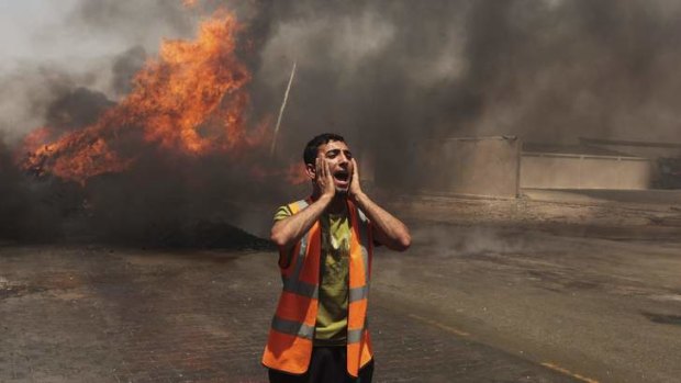 A Palestinian calls for fire-fighters in an industrial area in the east of Gaza City.