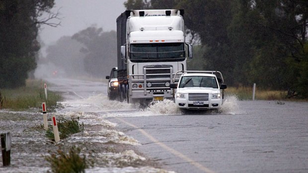 Trucks and cars battle to navigate floodwaters near Katamatite.