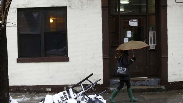 A woman walks past an apartment building that was raided by police.