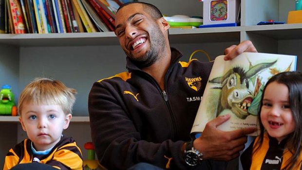 Josh Gibson reads a book to patients Ben and Chloe at The Royal Childrens Hospital.