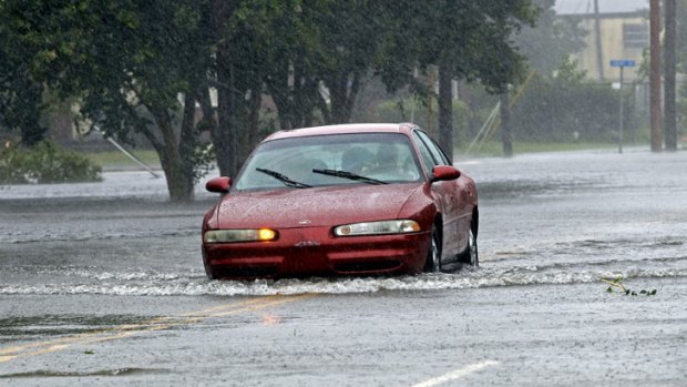 A man drives a car through a flooded street in New Bern, North Carolina.