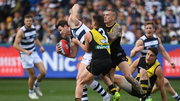 Patrick Dangerfield is tackled by Dustin Martin and Dion Prestia.