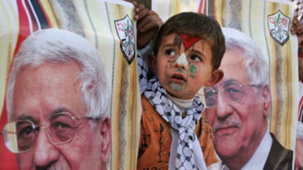 ’’God willing, we will soon have an independent state with its capital in Jerusalem’’ ... a young Palestinian boy peeps out from posters of Mahmoud Abbas.