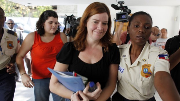 Under investigation … American missionaries Laura Silsby, 40, centre, and Charisa Coulter, 24, left, are taken to the courthouse. They remain in jail in Haiti.