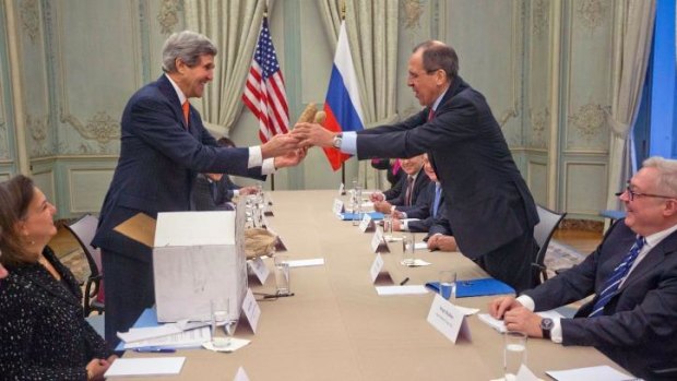 US Secretary of State John Kerry gives a pair of Idaho potatoes as a gift for Russia's Foreign Minister Sergey Lavrov (R) at the start of their meeting at the US Ambassador's residence in Paris.
