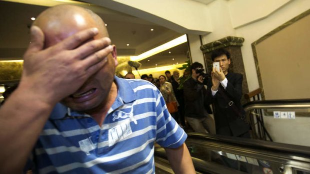 A relative of one of the passengers aboard the Malaysia Airlines flight grieves after hearing the news.