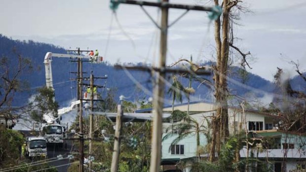 Fighting back after cyclone Yasi ...  electricity workers rig a temporary power supply for homes and businesses in Tully yesterday.