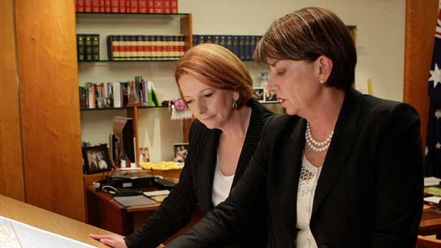 Prime Minister Julia Gillard looks at a map of Queensland with Queensland Premier Anna Bligh in the Prime Minister's office.