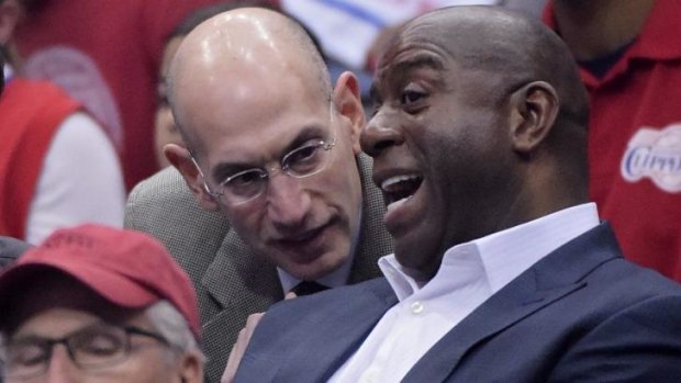 NBA boss Adam Silver, left, talks with Magic Johnson during the NBA play-off game on the weekend.