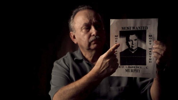 Arthur Budzinski points to a poster of his abuser, Father Lawrence Murphy.