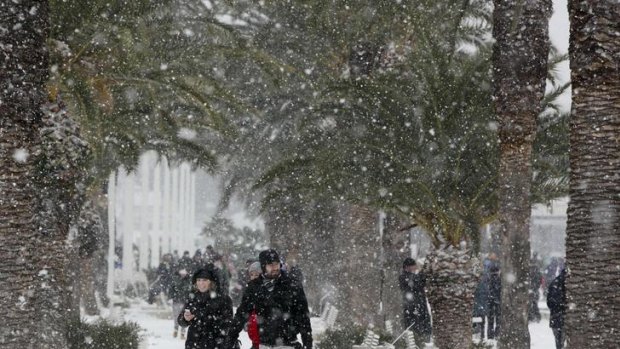 People walk along a snow covered street in Split, Croatia.
