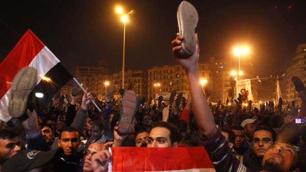 Angry ... protesters wave their shoes in disgust after President Hosni Mubarak's announcement.