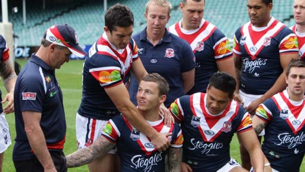 One for the team . . . the Roosters, including coach Brian Smith, left, assemble for the camera during a fan day at Sydney Football Stadium yesterday.