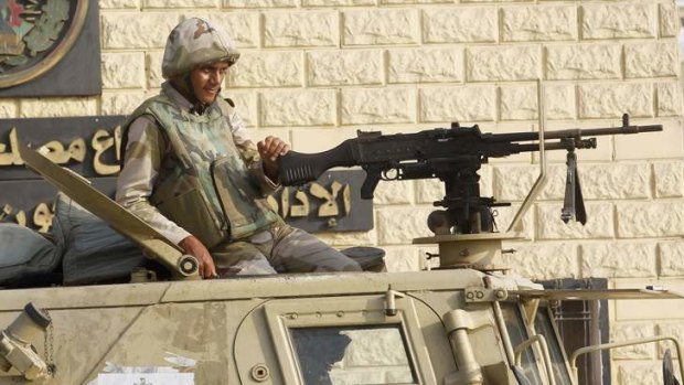 An Egyptian Army soldier guards on an armoured personnel carrier.