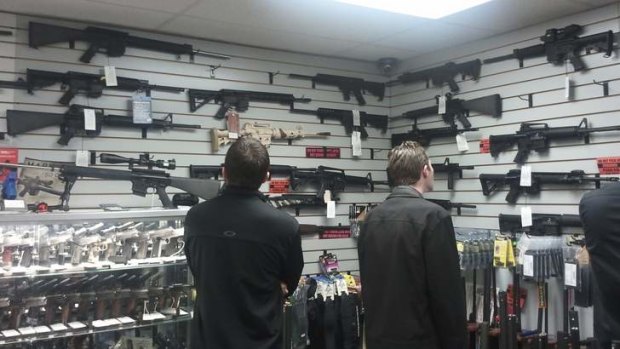 Gun shopping ... customers compare semi-automatic weapons on display at a shop in Los Angeles this week.