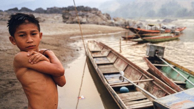 A boy stands on the banks of the Mekong River near the relocation site for a Lao village, which was moved to make way for the Xayaburi Dam.