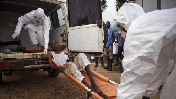 Health care worker assist a suspected Ebola sufferer in Sierra Leone. Organising workers in Africa has been a problem.