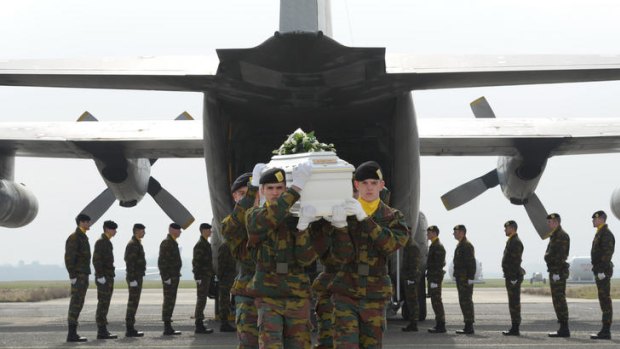 Belgium Defence Force soldiers carry coffins of those killed in Switzerland.