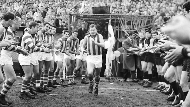 North Melbourne captain Allan Aylett runs on to the ground to play his 200th league game.