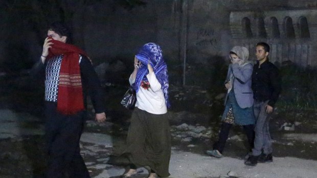 People walk after they were rescued from a guest house that was attacked by gunmen in Kabul.