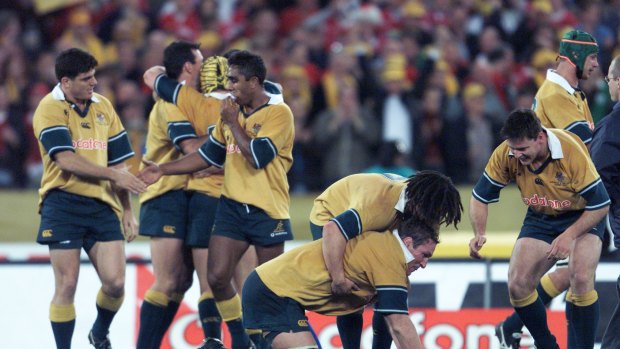 James Holbeck, on the left, celebrates with his Wallabies teammates after playing the Lions in 2001. 